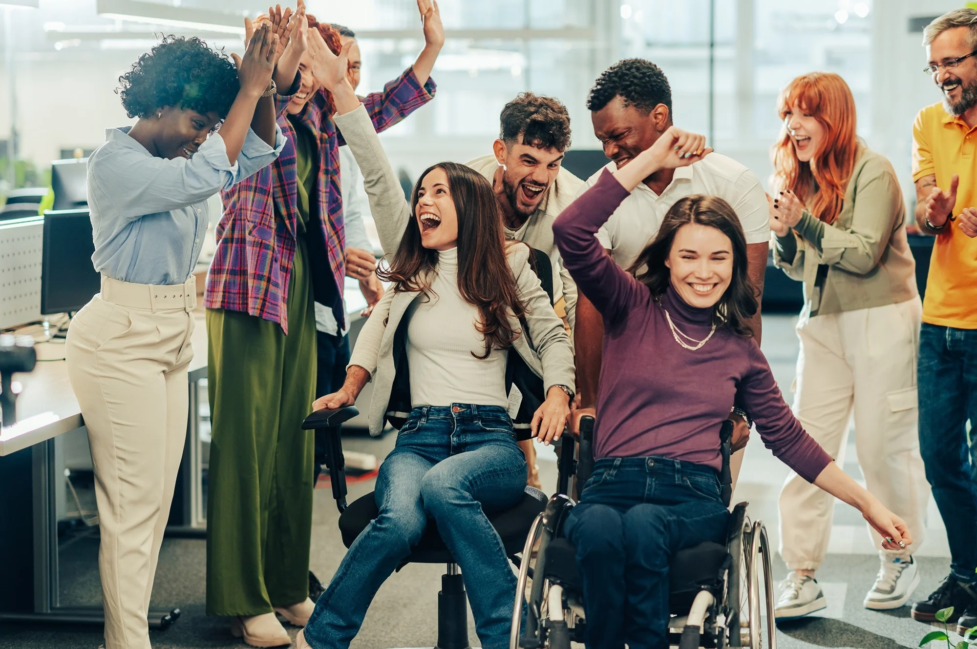 Laughing female racing woman with disability in an office chair race